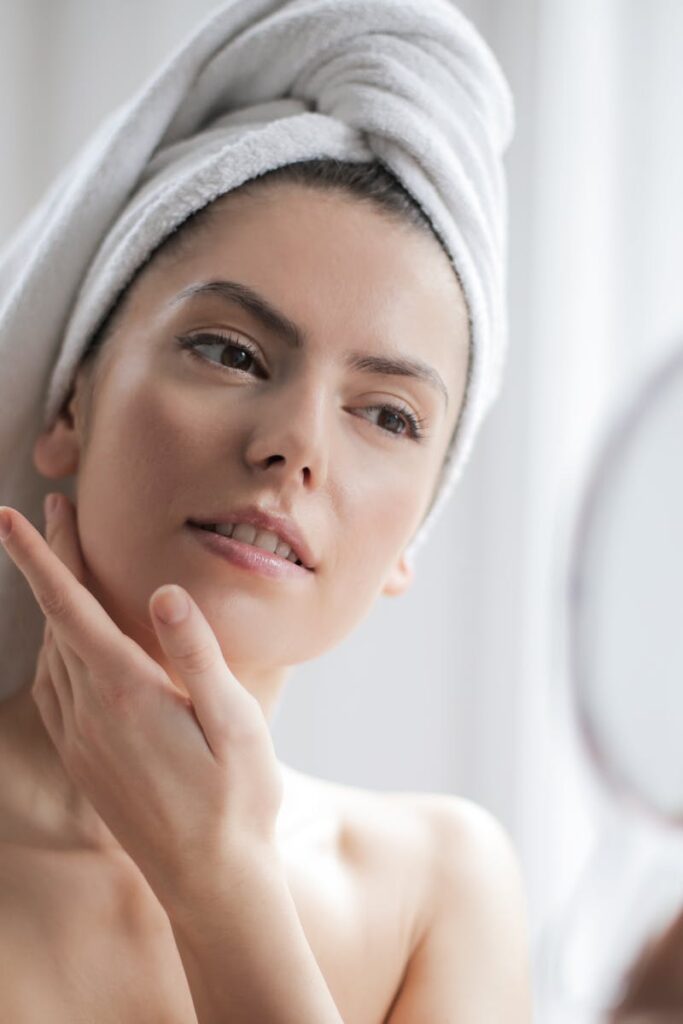 A serene and elegant woman enjoys a skincare ritual, enhancing her natural beauty in the comfort of her home.